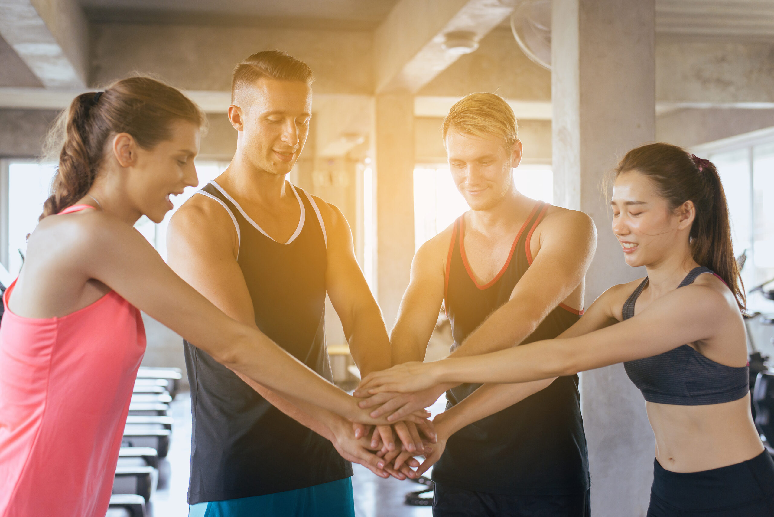 Une équipe de sportif se joint les mains en signe de victoire.