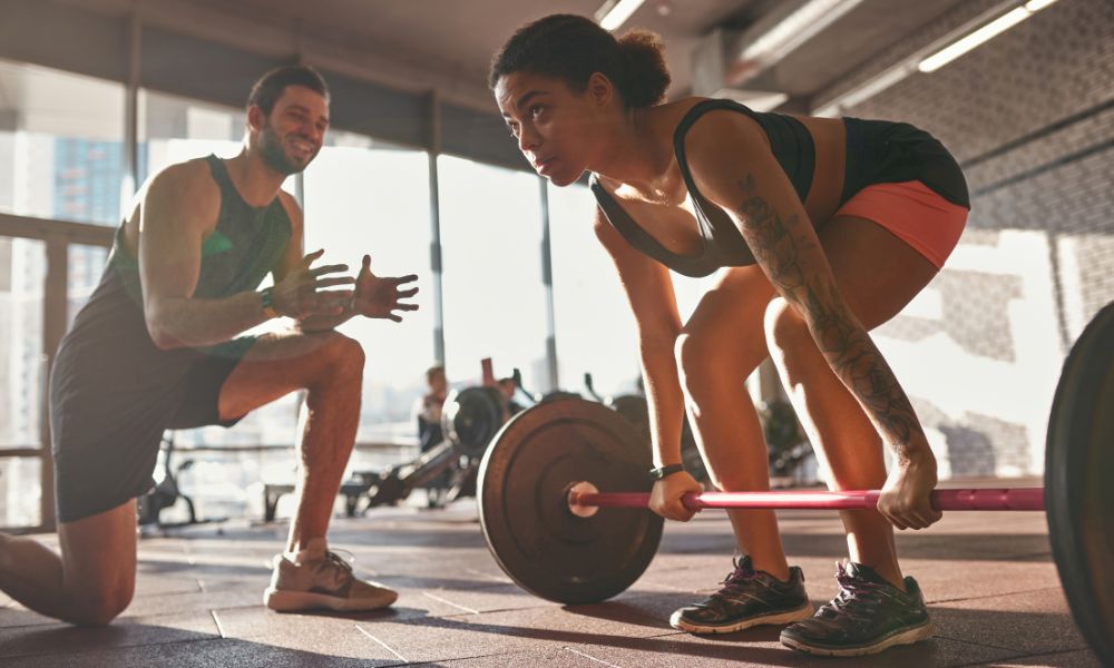 femme et coach sportif entrainement de musculation