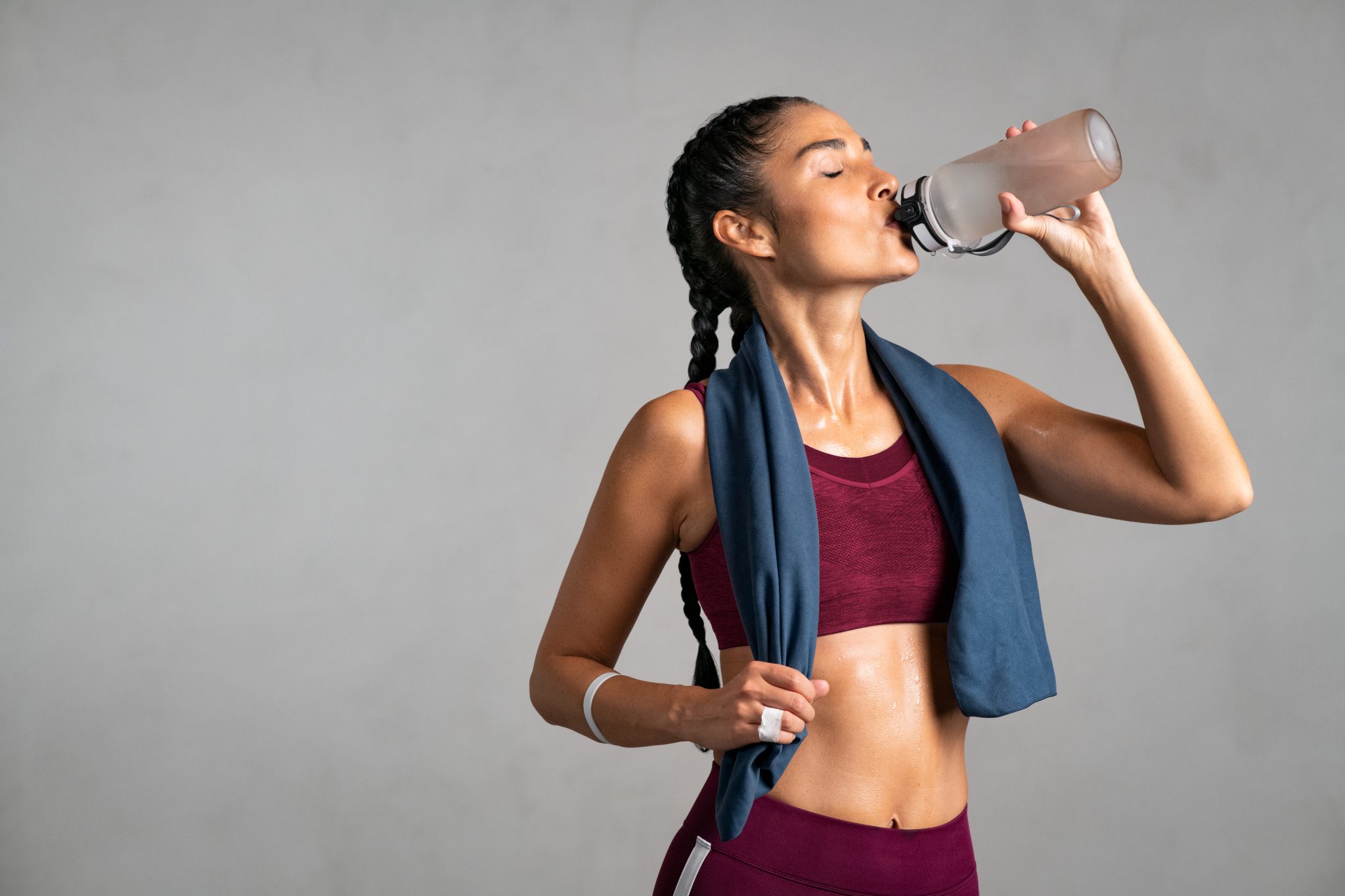 fit woman drinking from water bottle